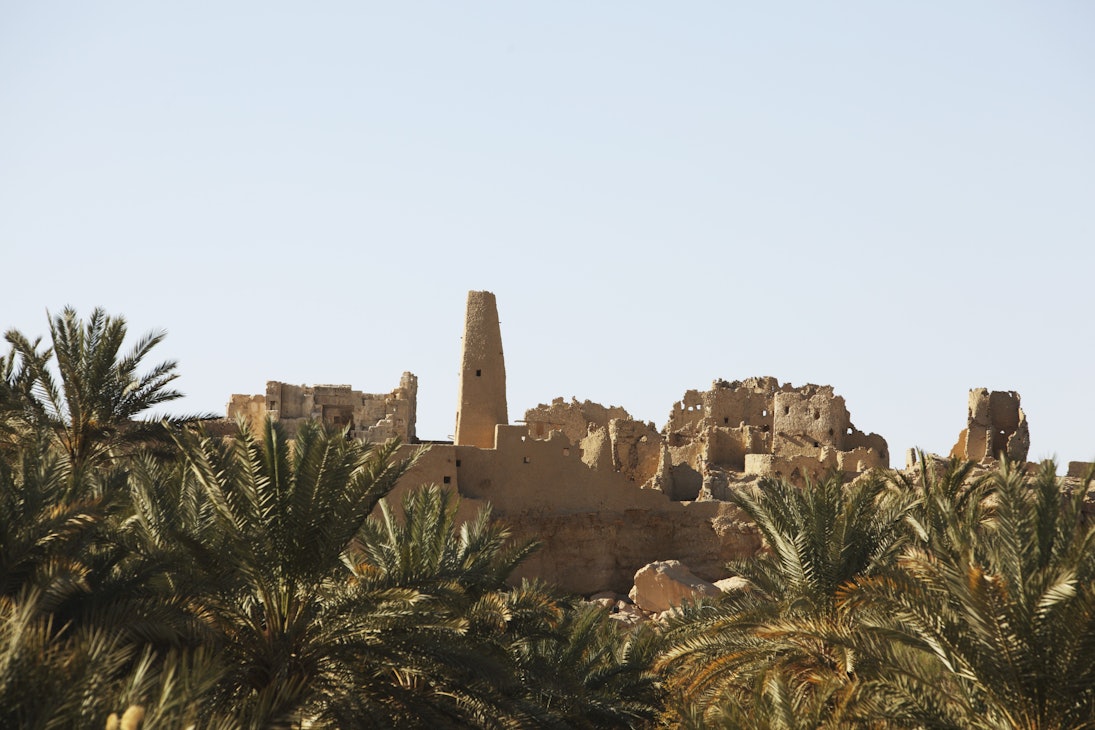 Temple of the Oracle (left) amongst ruined mud buildings.