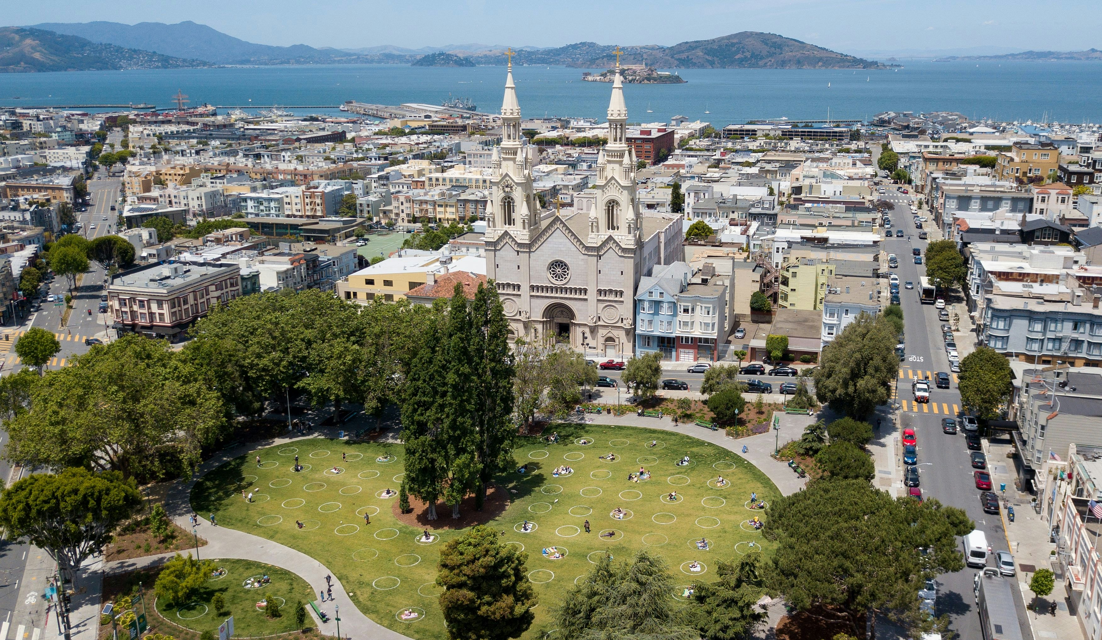 An aerial view shows painted circles in the grass to encourage people to social distance at Washington Square in San Francisco, California