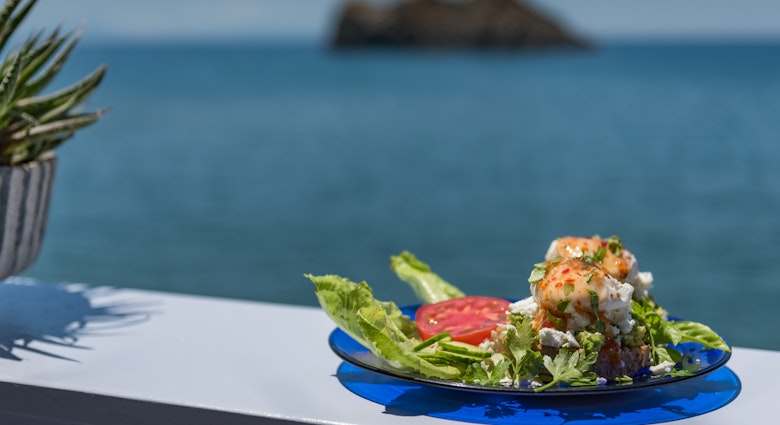 Smashed Avocado on homemade bread with crumbled feta cheese and topped with poached egg and sweet chilli sauce. Food served on a plate by the sea at Skala Eresou, Lesvos, Greece.
998306906