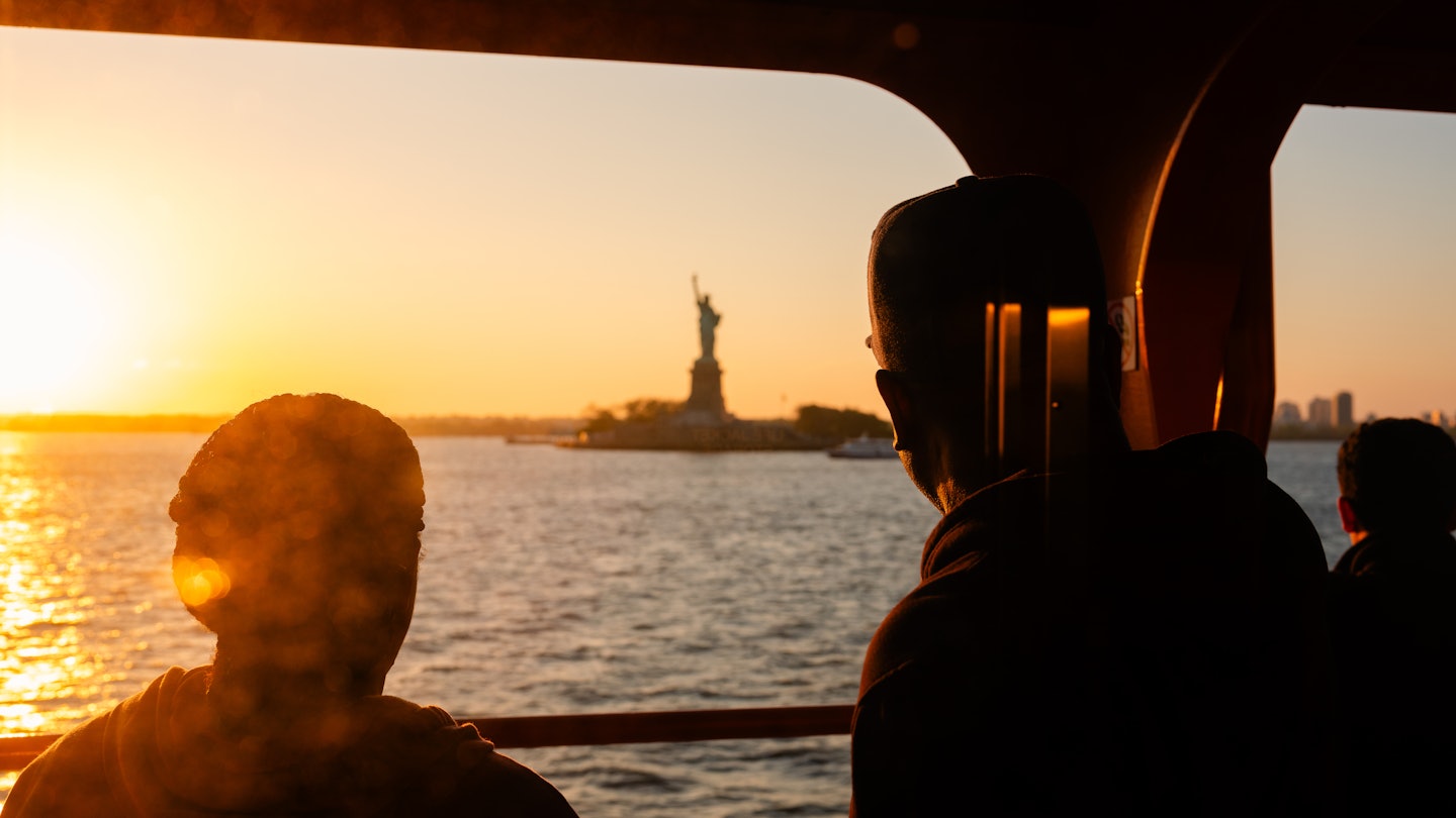 Anthony Nazario for Lonely Planet
The Staten Island Ferry from Staten Island, NY to Manhattan. Commuters and tourists enjoy the sun setting on the Statue of Liberty.