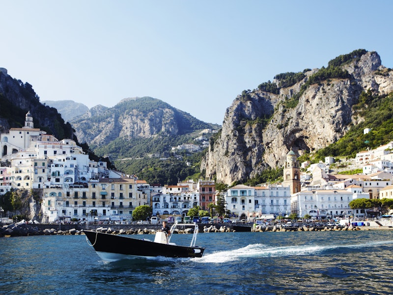 Passing boat on Tyrrhenian sea with Amalfi town in background.