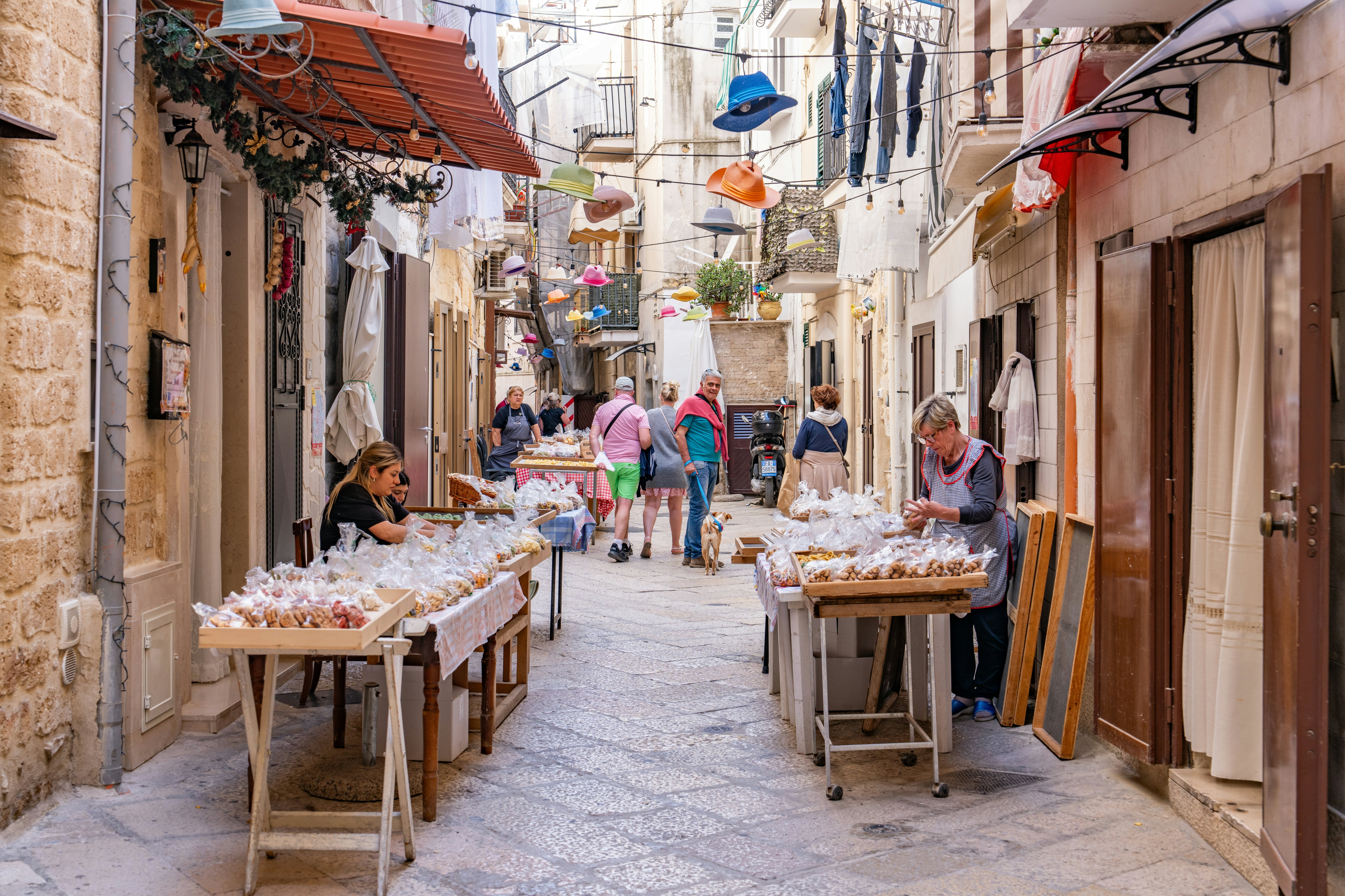 Local women selling authentic hand made pasta in the old town of Bari, Italy