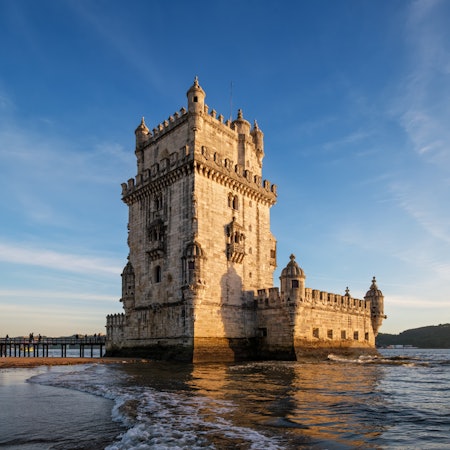 The ornate Belem Tower is surrounded by the waters of high tide in Lisbon.